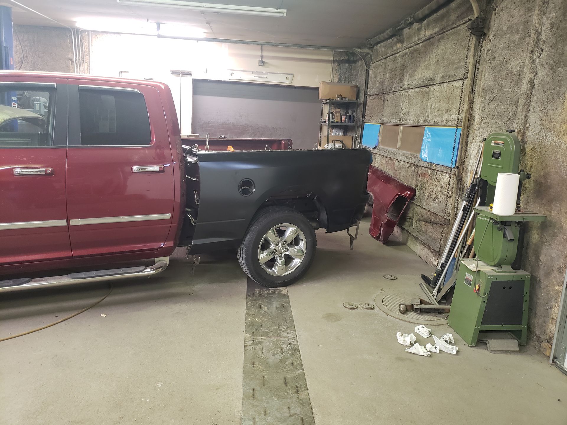 a red truck is parked in a garage next to a black truck