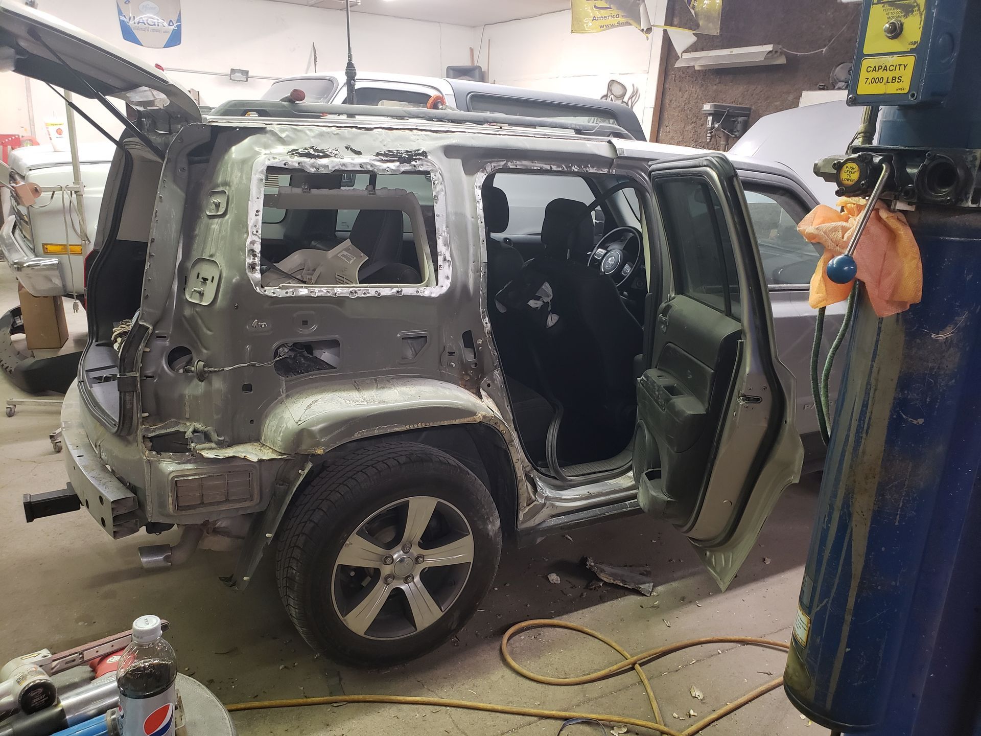 a jeep is being repaired in a garage with its doors open