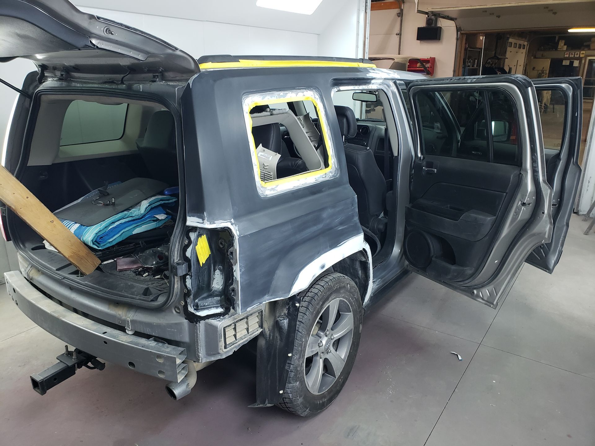 a car is being repaired in a garage with the trunk open