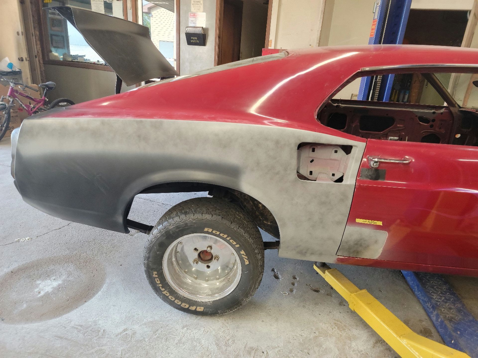 a red car is sitting on a lift with the hood open