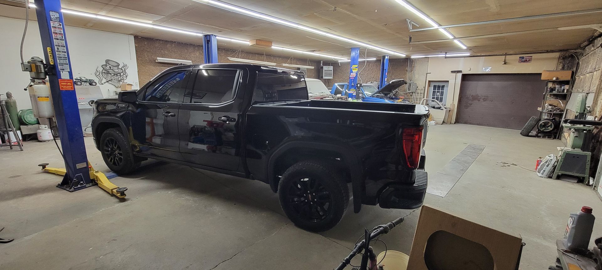 a black truck is parked in a garage on a lift