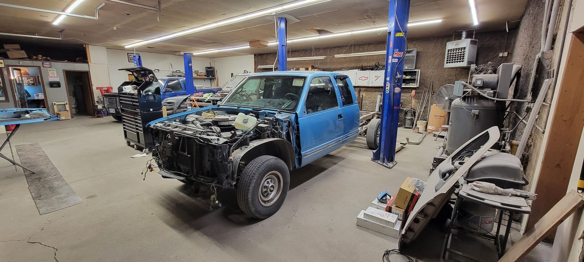 a blue car is being worked on in a garage
