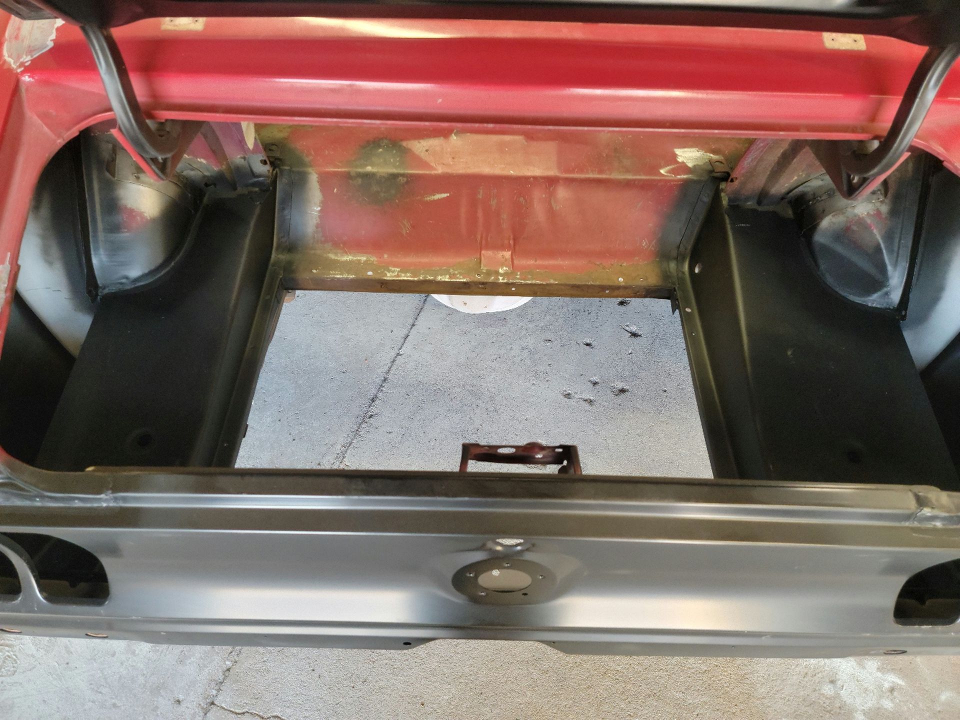 the trunk of a red car is open and empty