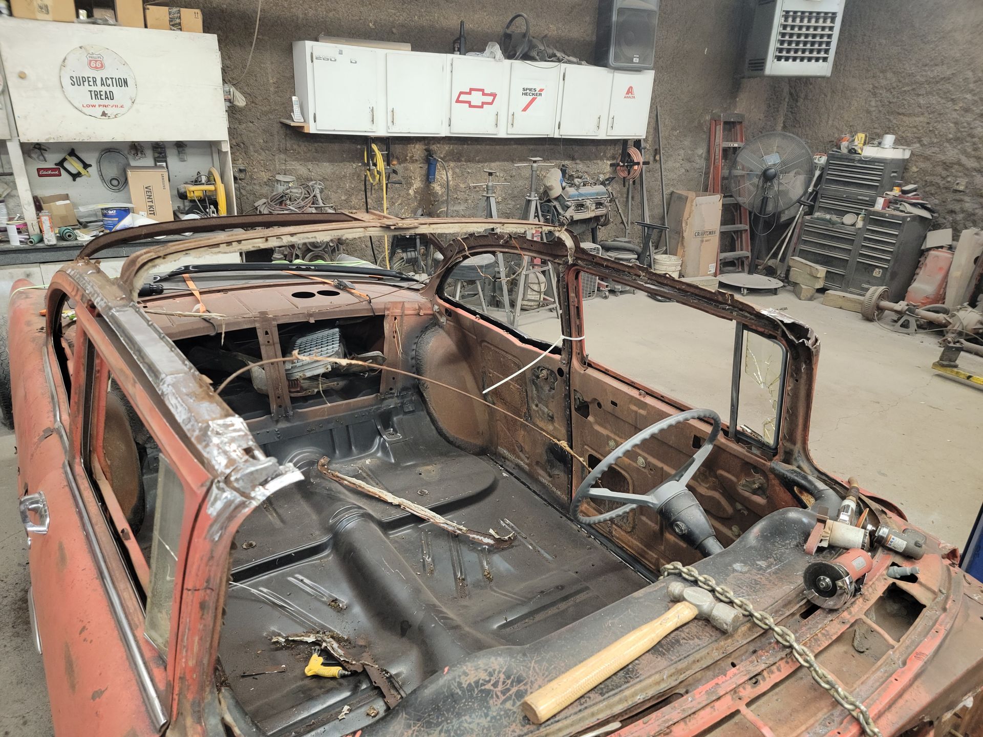 an old rusty car is being restored in a garage