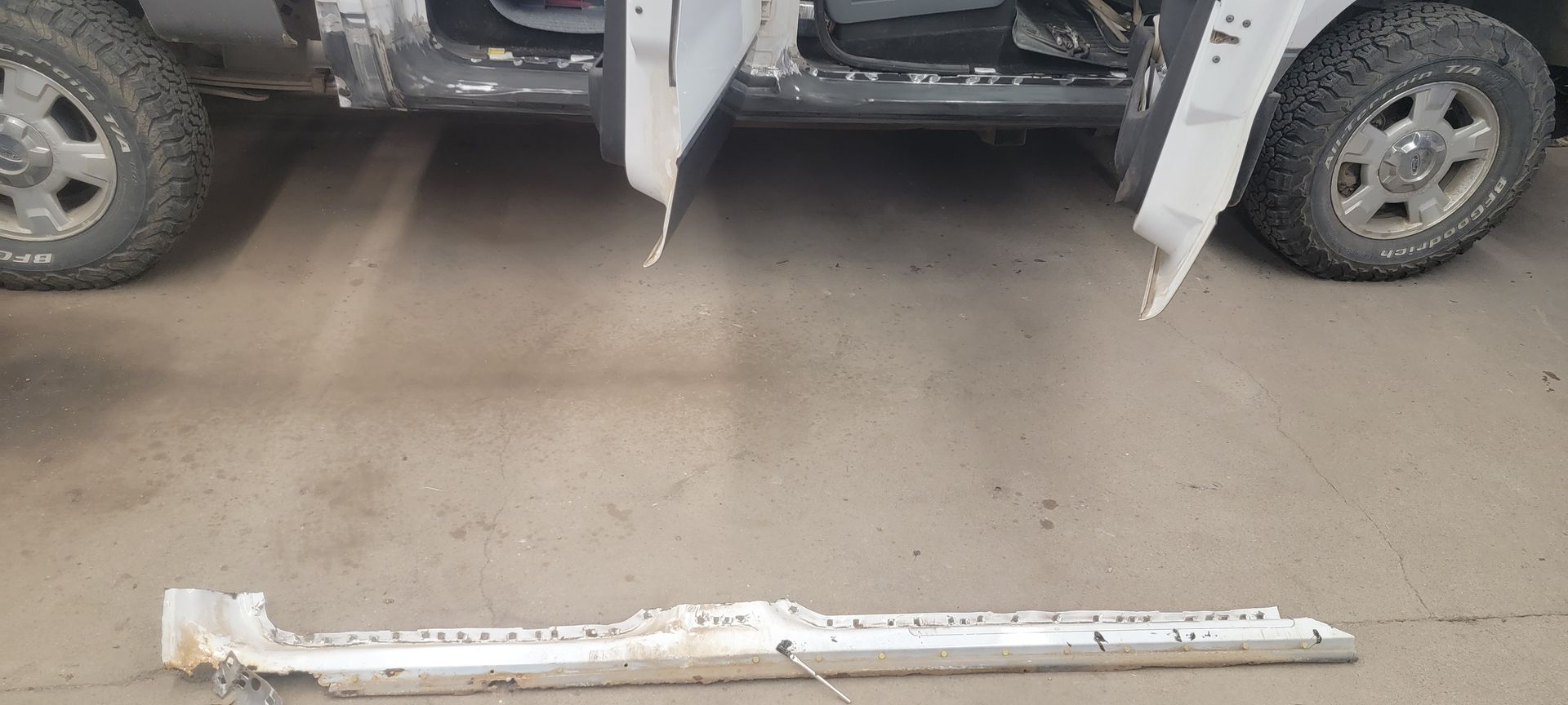 a piece of metal is laying on the ground next to a car