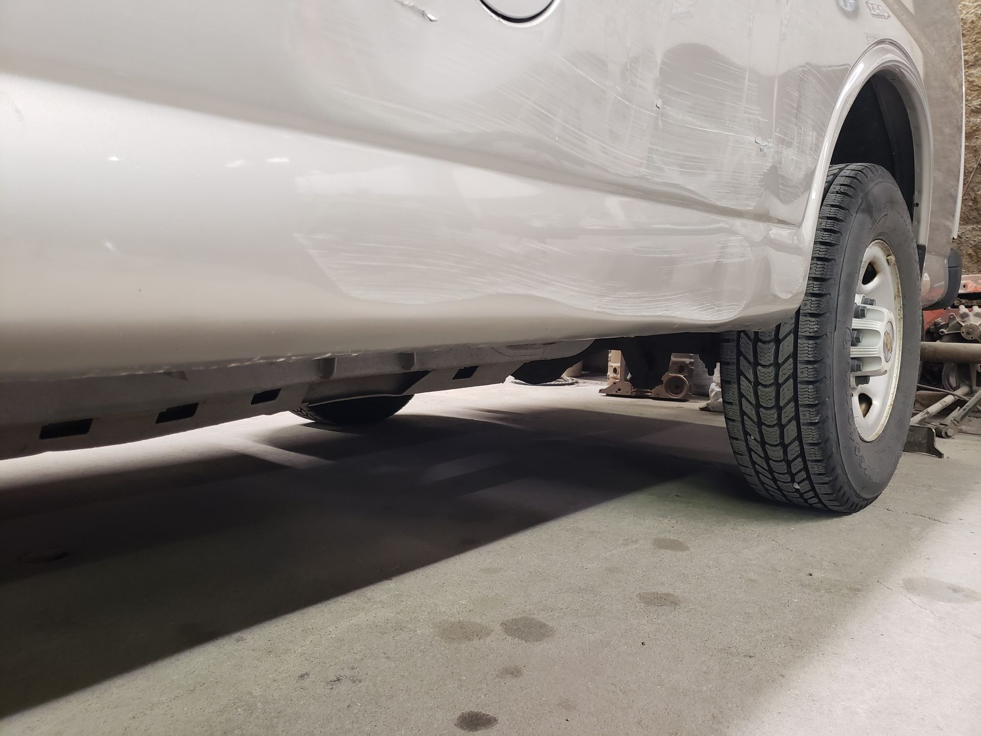 a close up of a car 's fender and tire in a garage