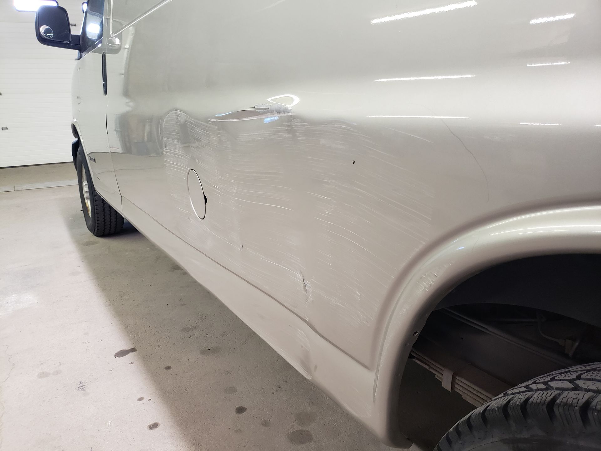 a white van is parked in a garage next to a garage door