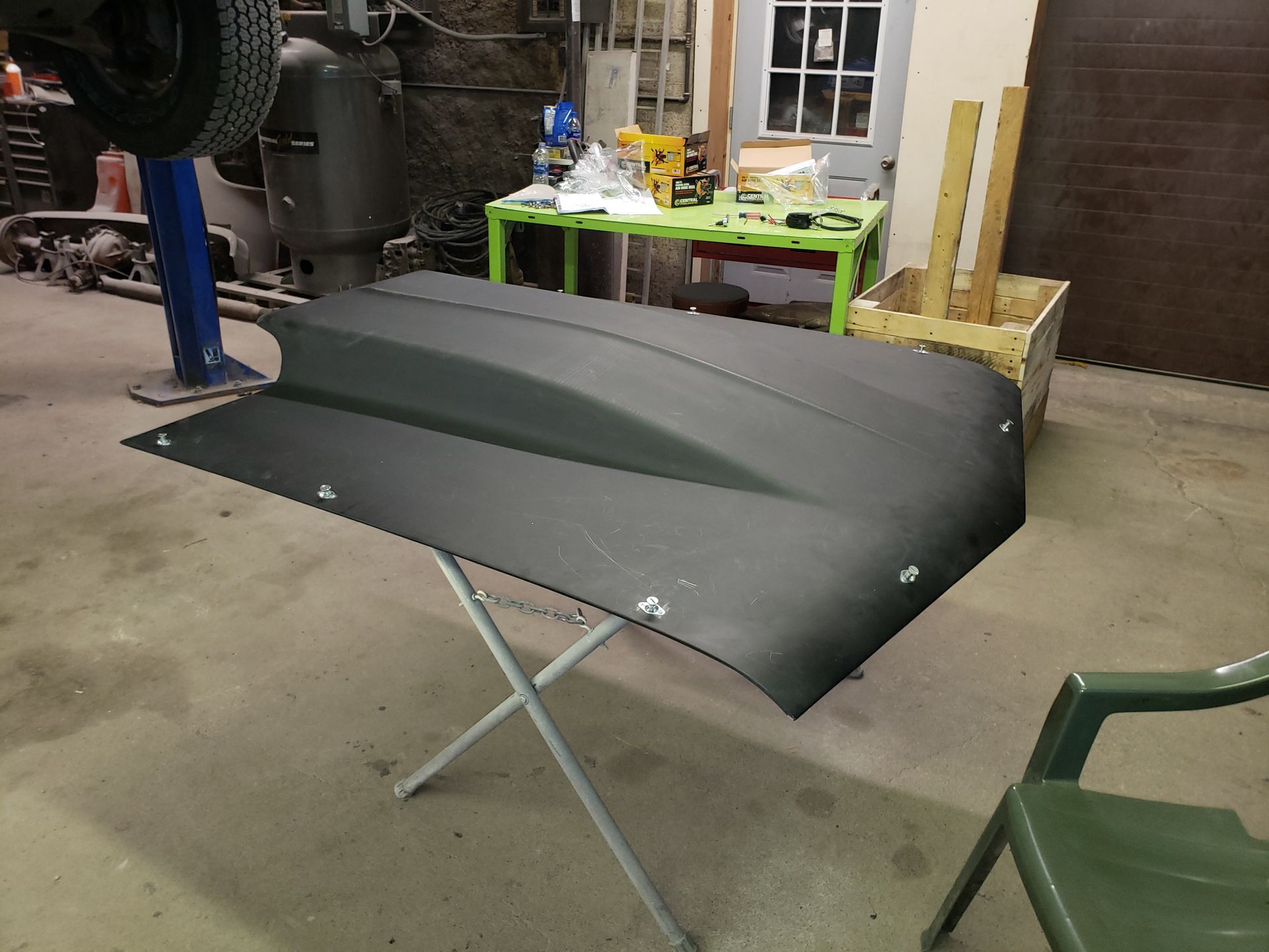 a hood is sitting on a table in a garage