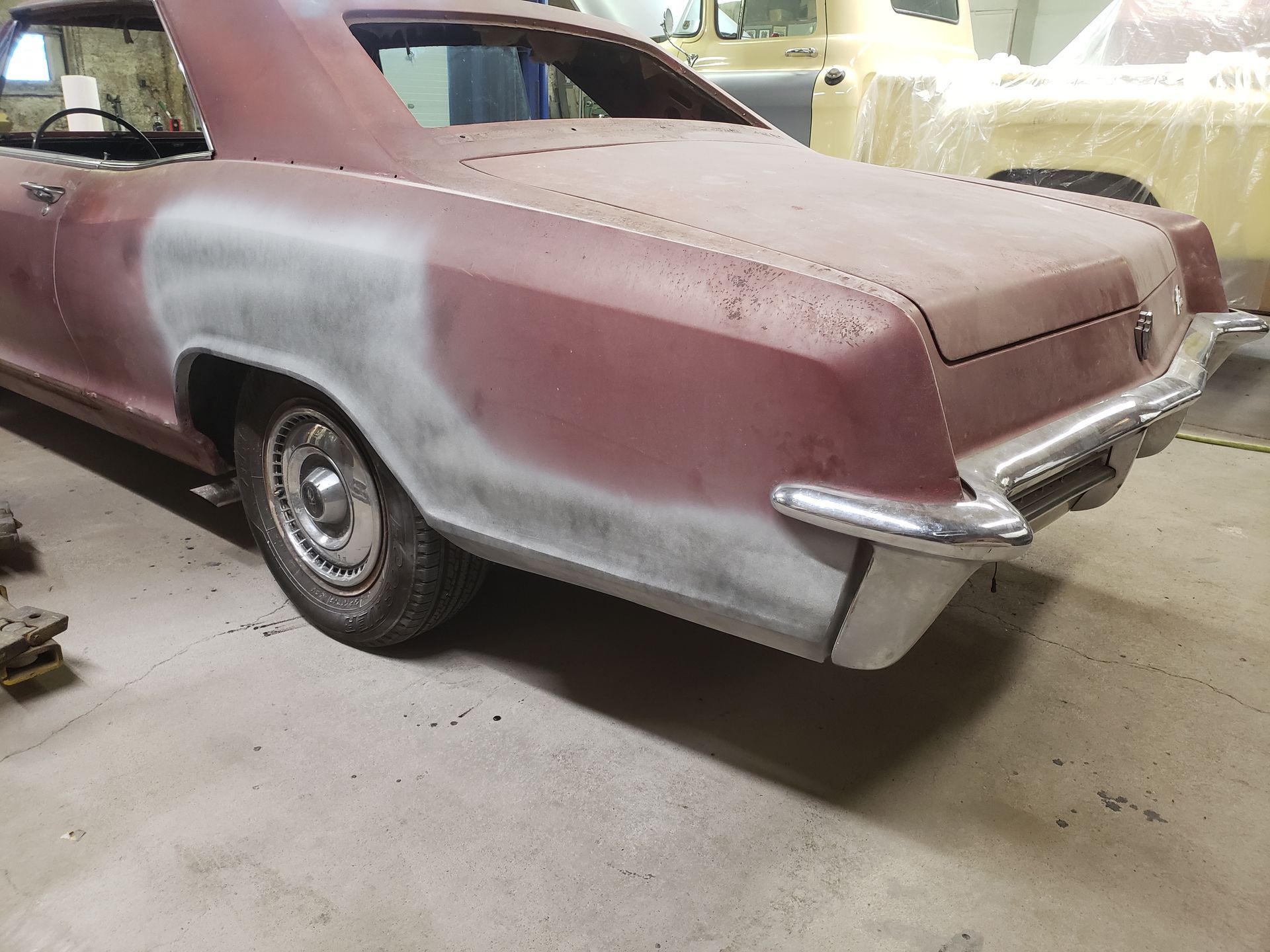 an old rusty car is parked in a garage