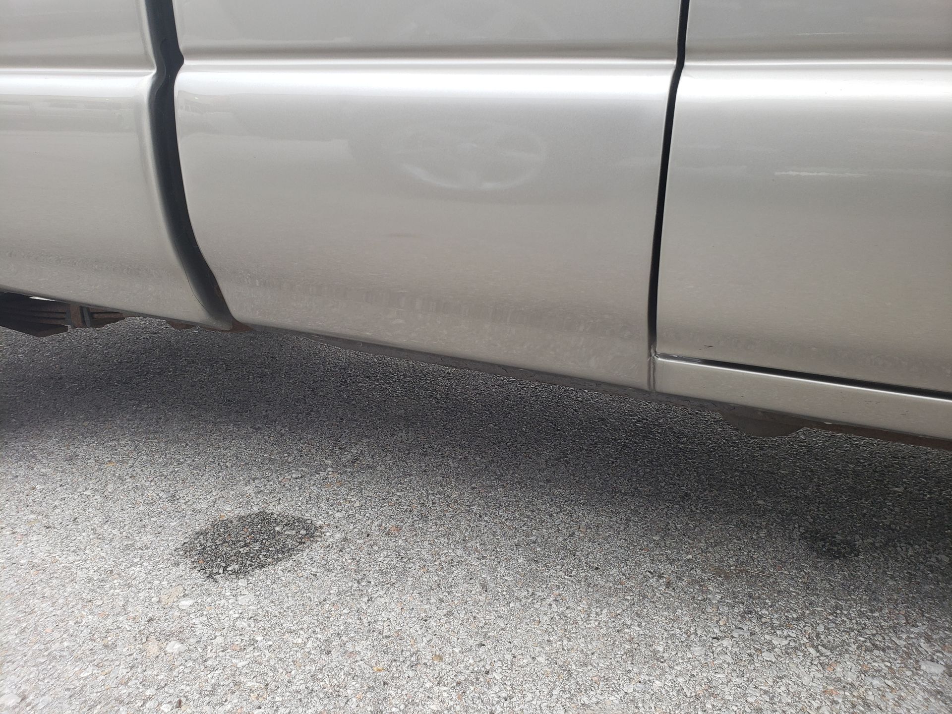 a silver truck is parked on the side of the road