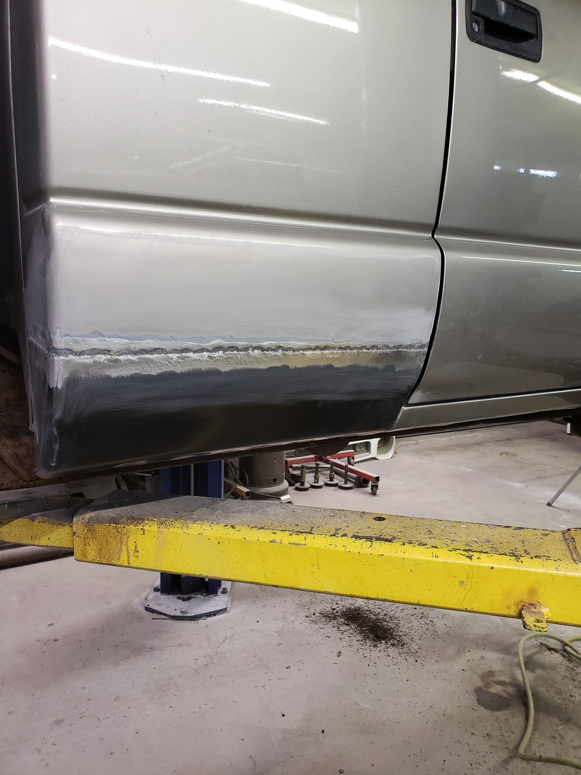 a truck is sitting on a yellow lift in a garage