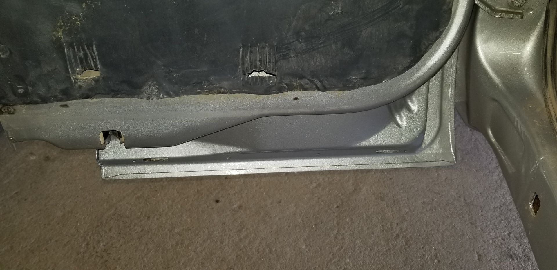 a close up of a car door on a carpeted floor