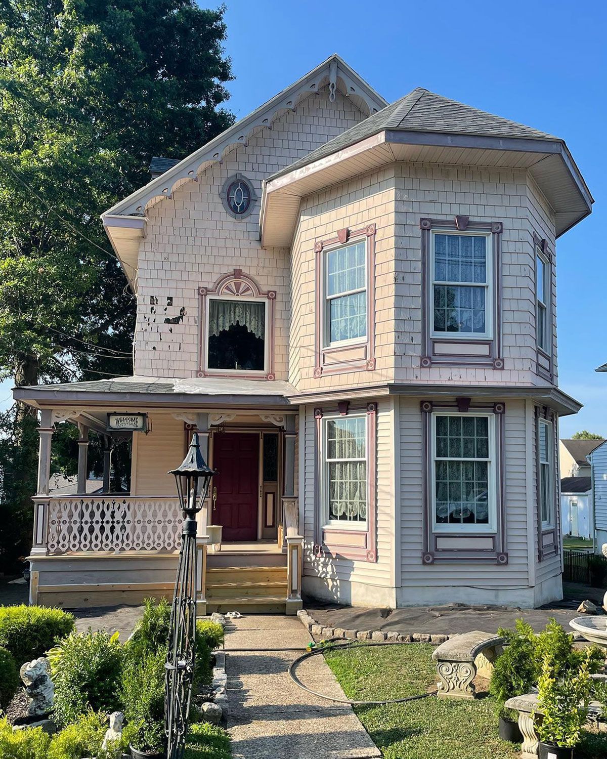 A white house with a red door and a porch.