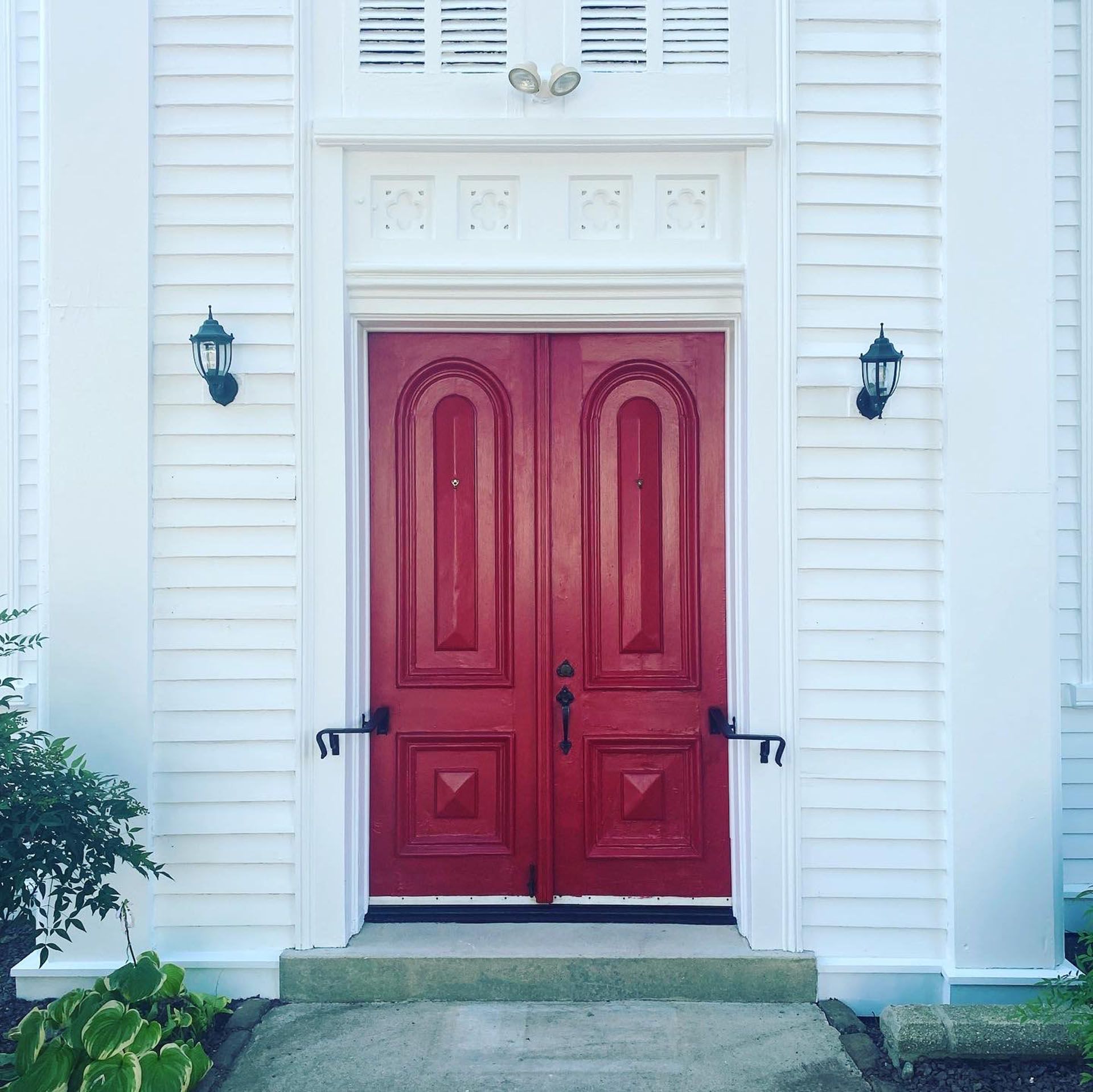 A red door is on a white building