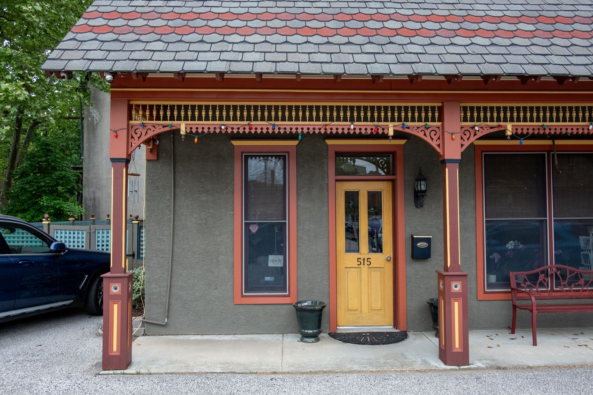 A car is parked in front of a house with a yellow door