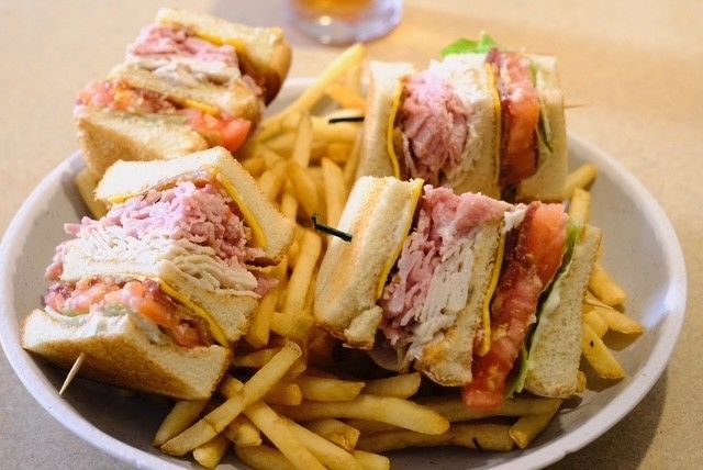 Club sandwiches with fries on a plate.