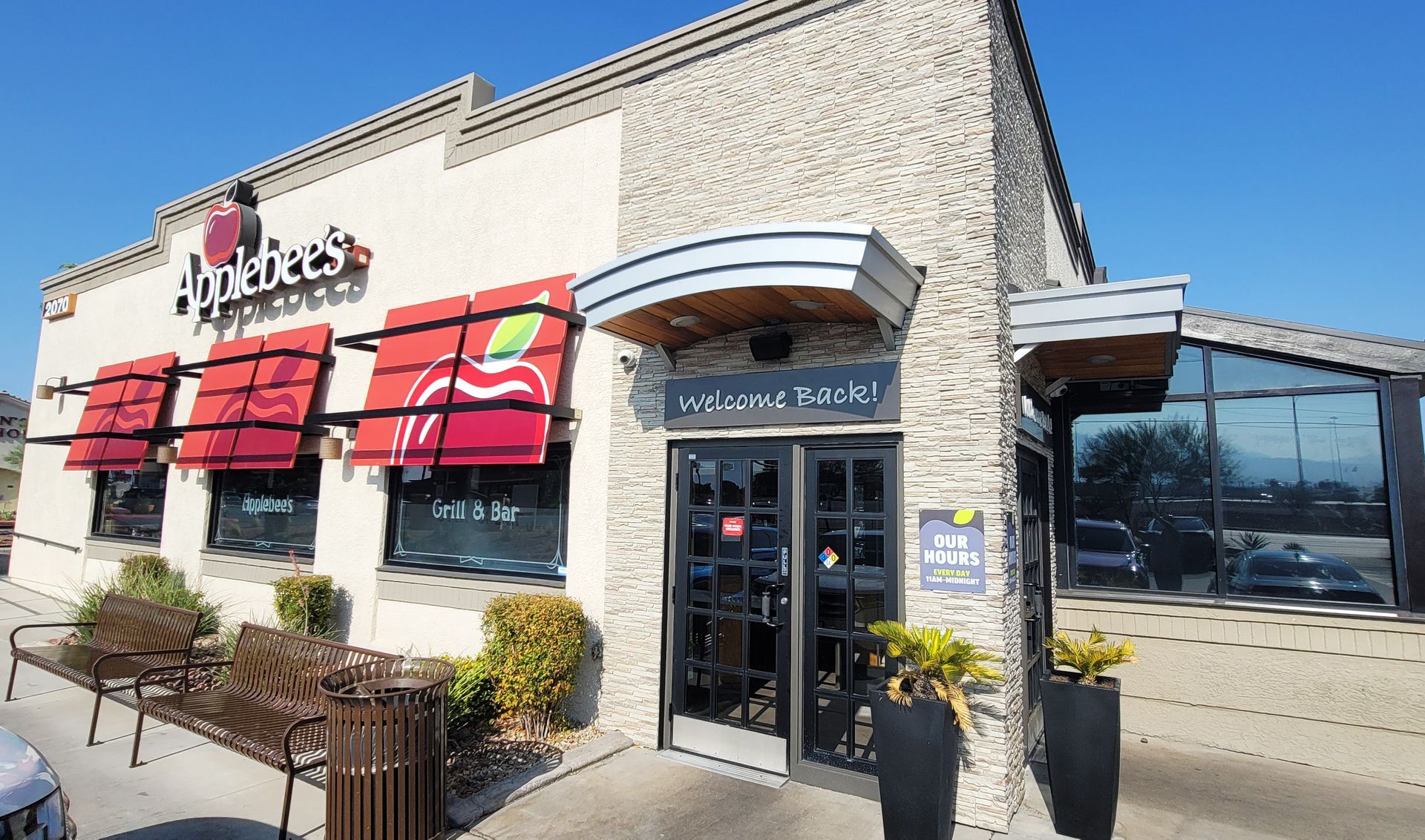 The outside of an applebee 's restaurant with red awnings