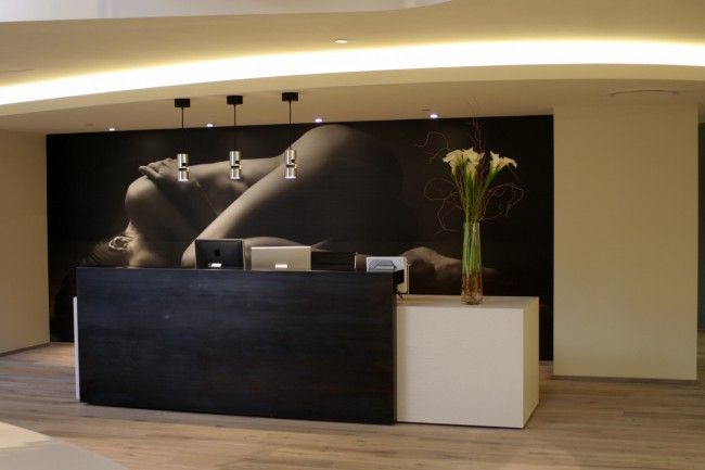 A reception desk with a picture of a woman on the wall behind it