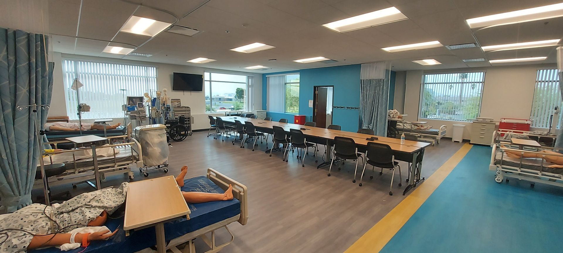 A large room with a lot of hospital beds and tables.