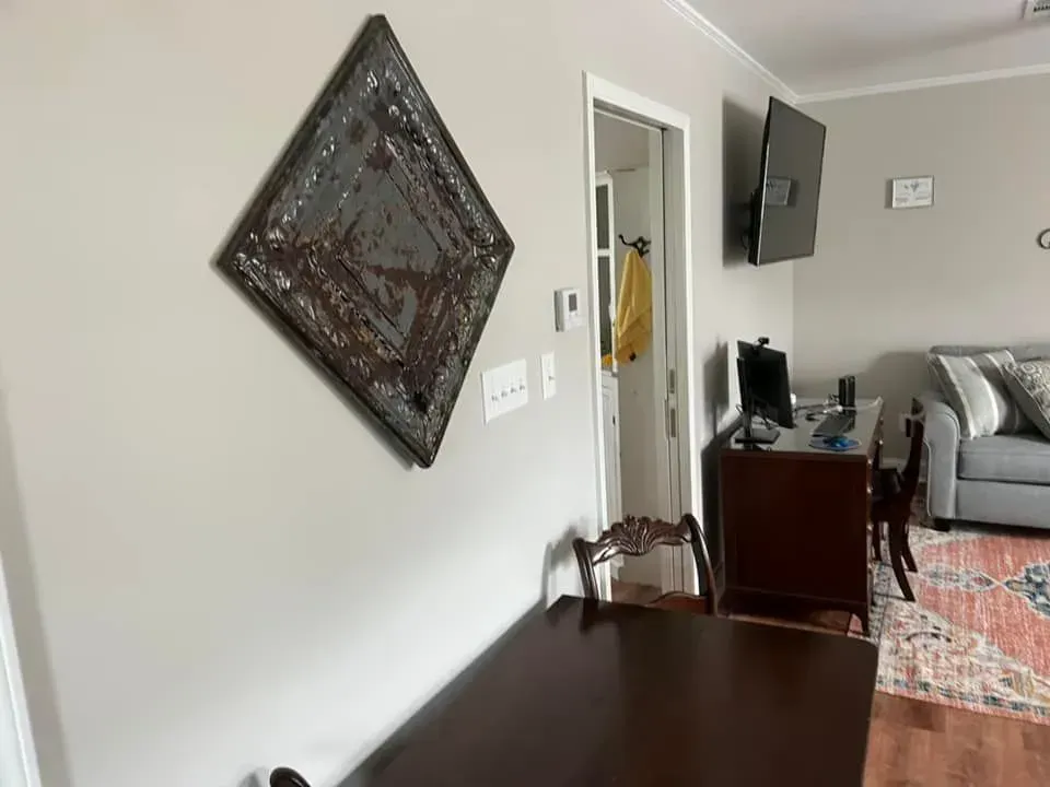 A living room with a table , chairs , a couch and a television.