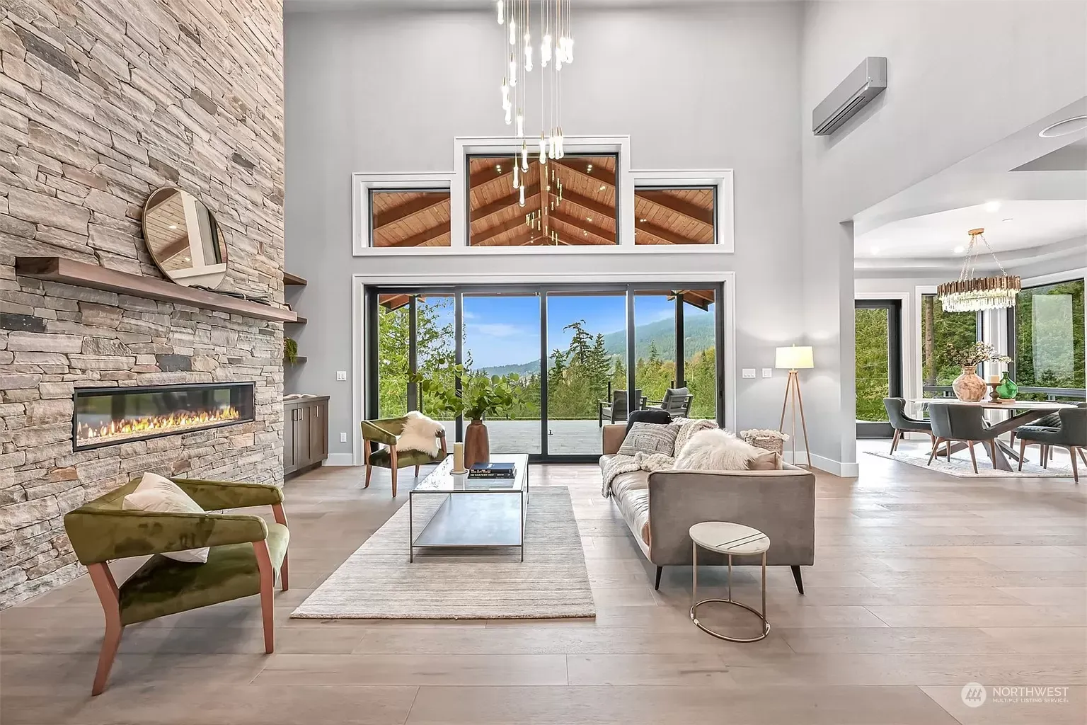 A living room with a couch , chairs , fireplace and sliding glass doors.