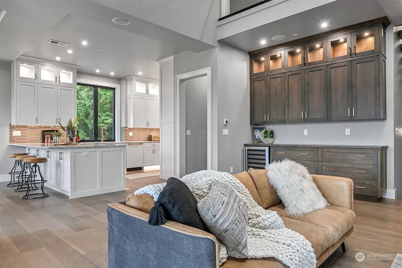 A living room with a couch and a kitchen in the background.