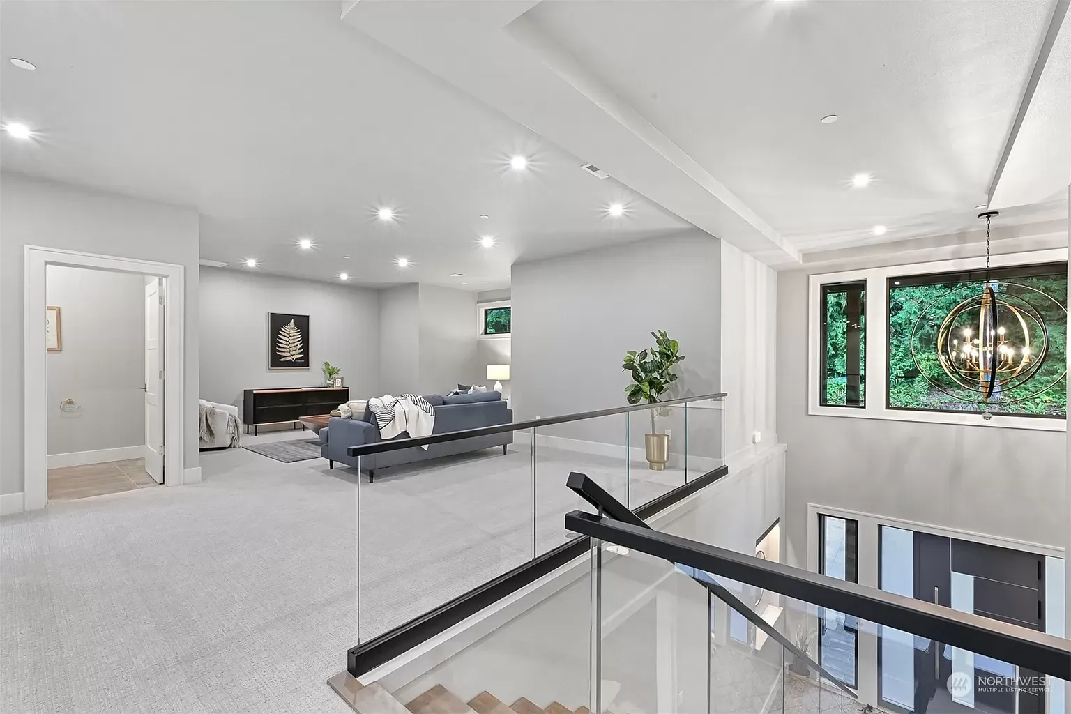 A living room with a couch and stairs in a house.