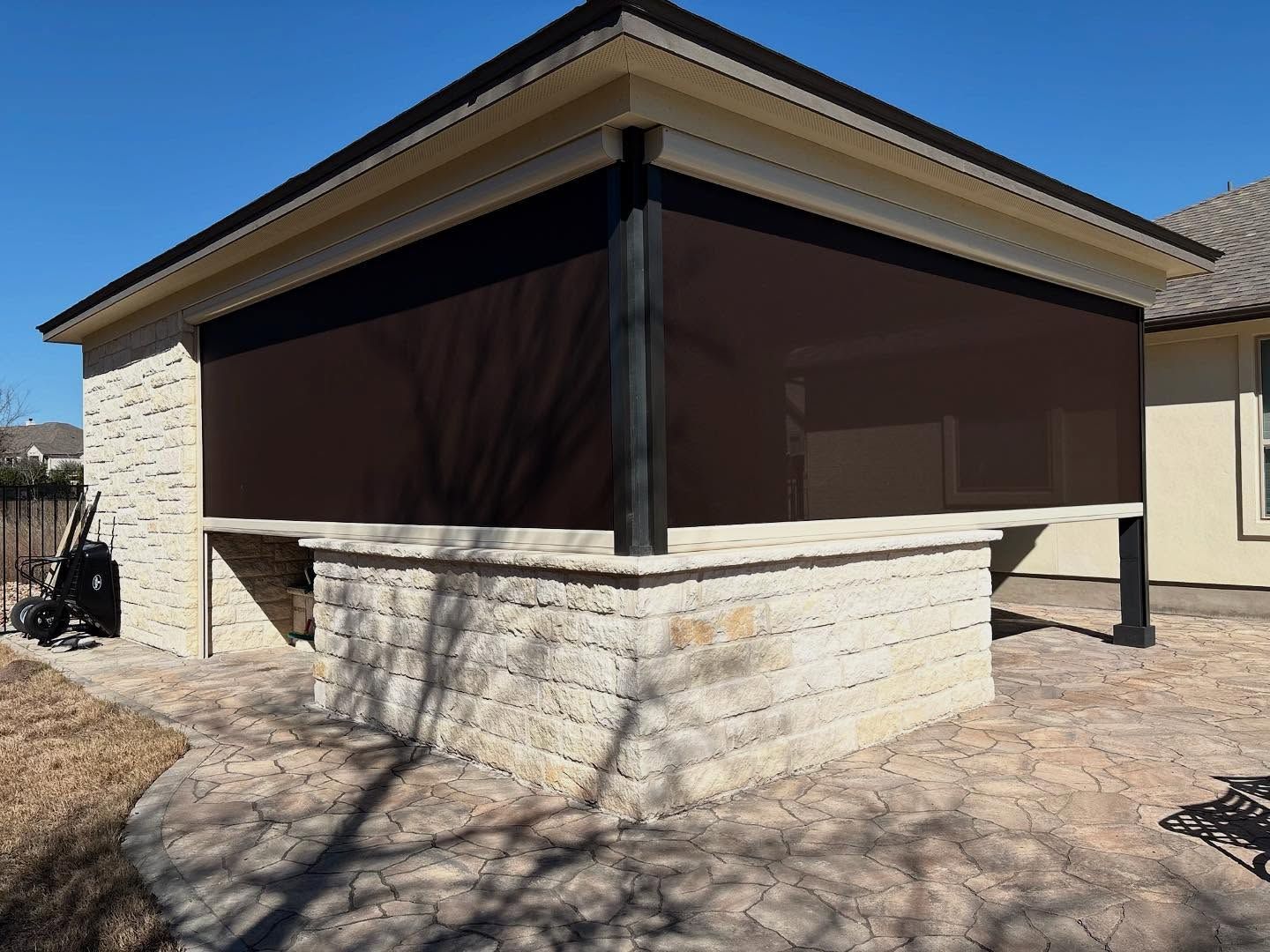 Brown outdoor shade covers a brick patio structure.