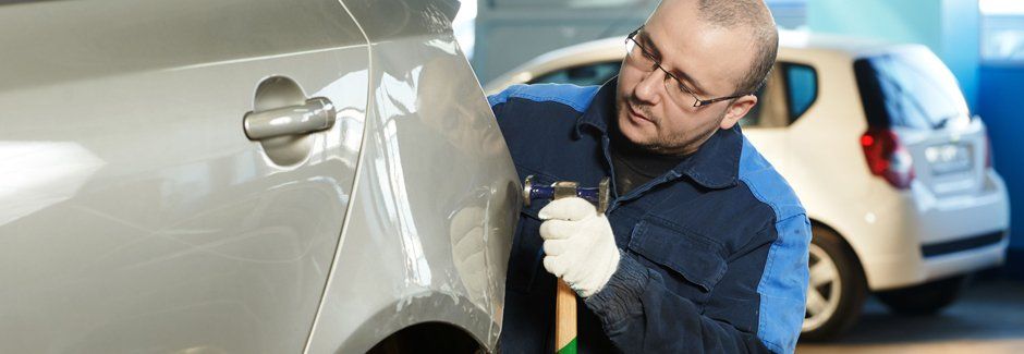 Auto body technician completing a repair