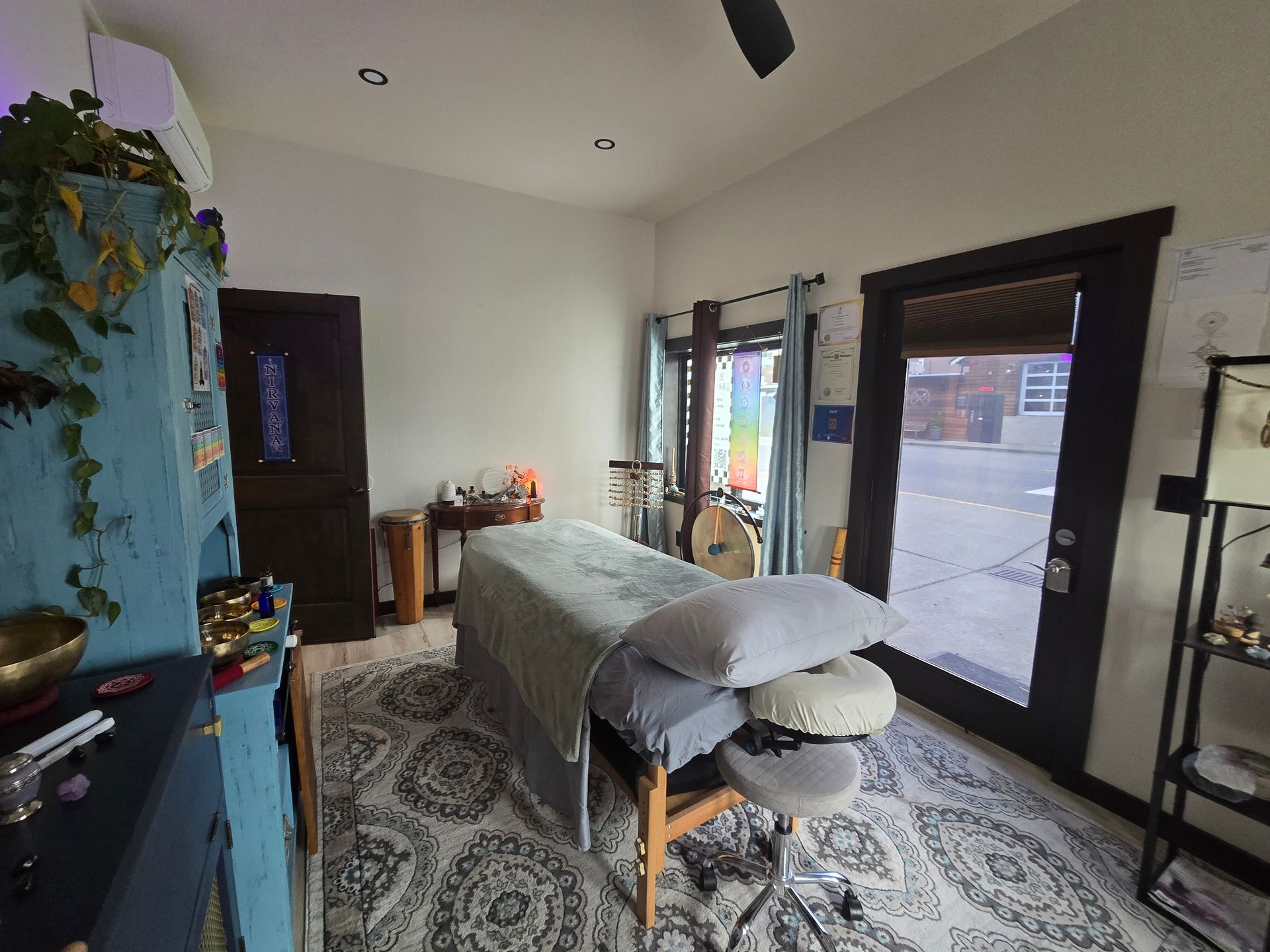 A room with a massage table and a ceiling fan