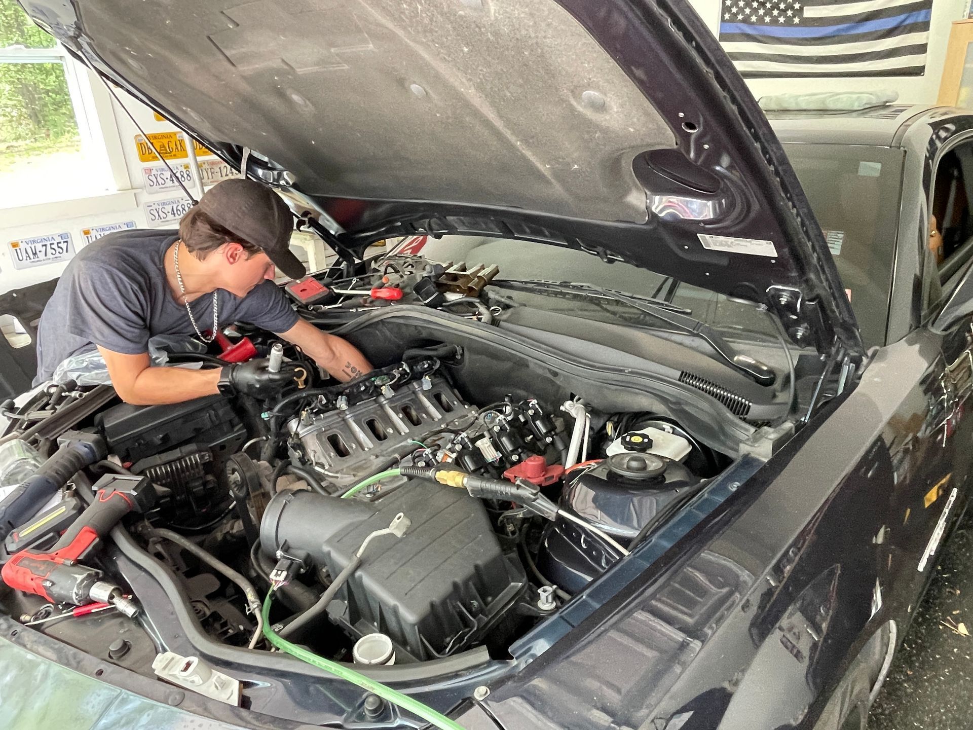 Mechanic inspecting a car engine in a garage with the hood open