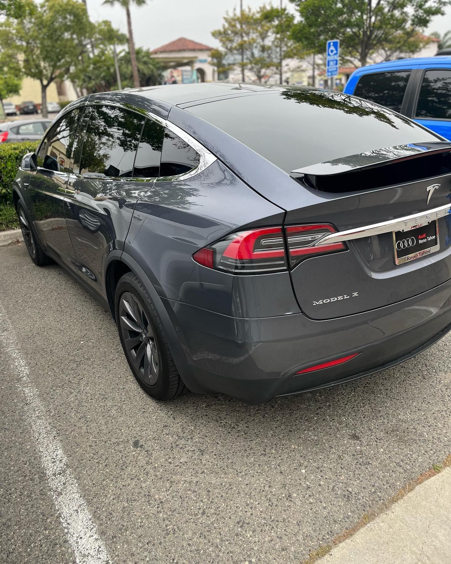 Dark gray Tesla Model X parked in a parking lot.