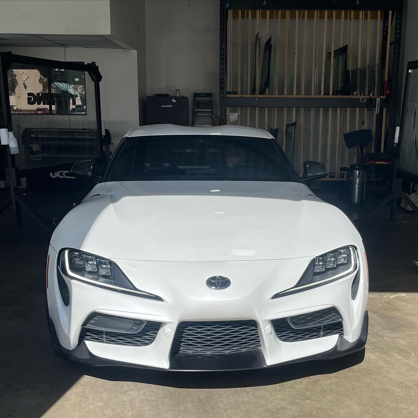 White Toyota Supra parked inside a garage.