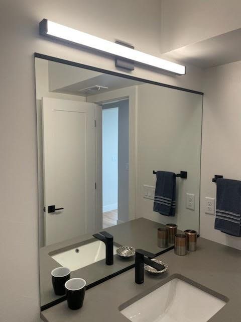A bathroom with a sink and a large mirror