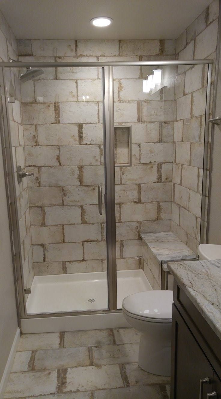 A bathroom with a walk in shower , toilet and sink.