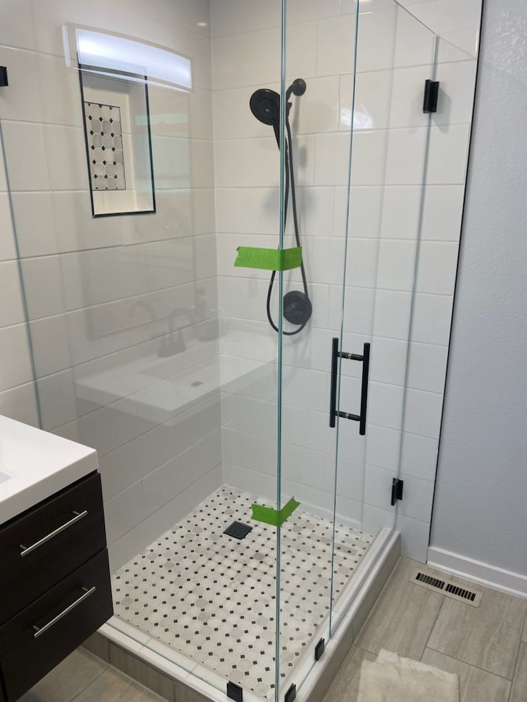 A bathroom with a walk in shower and a sink.