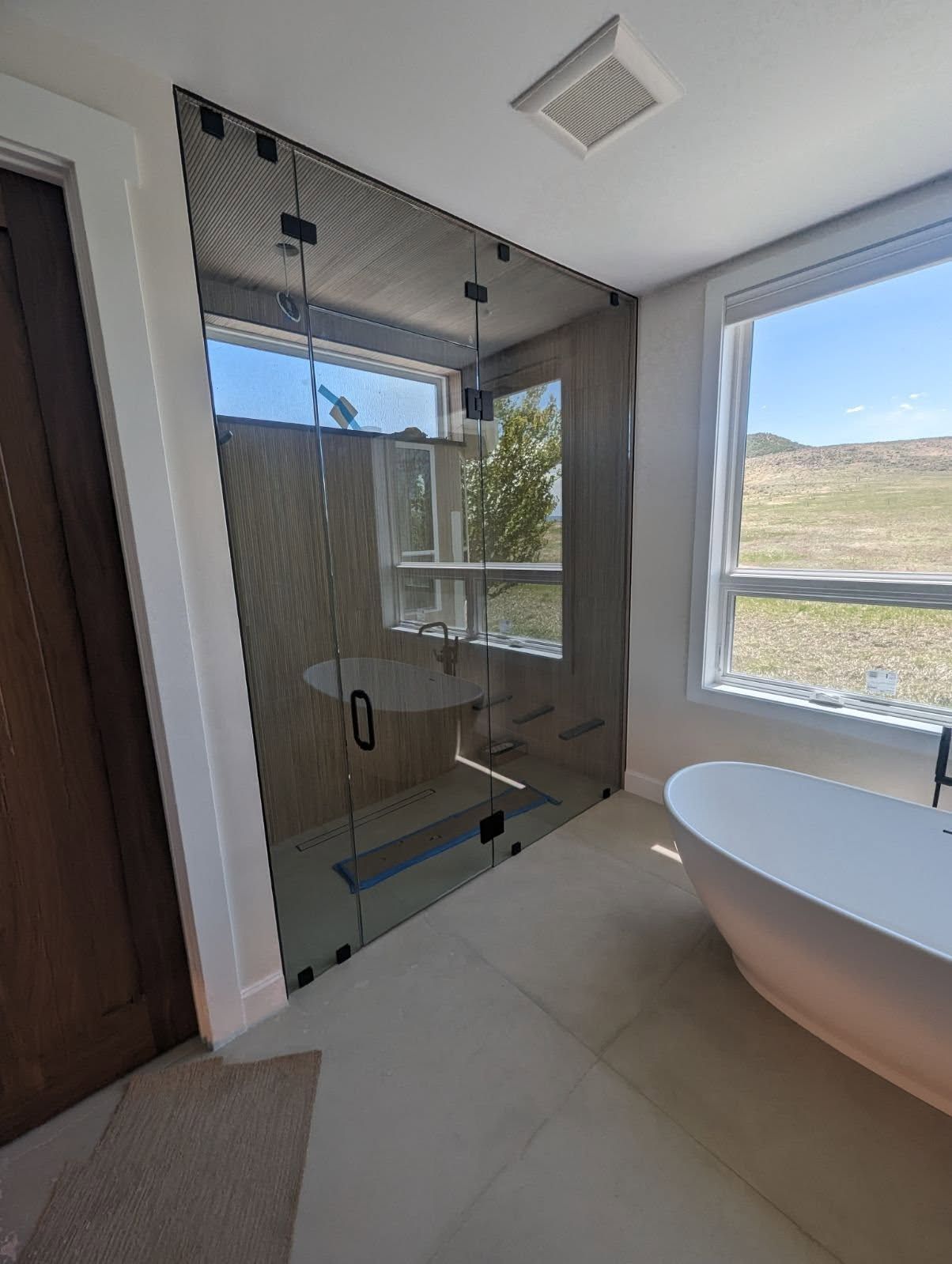 A bathroom with a tub , shower , and window.