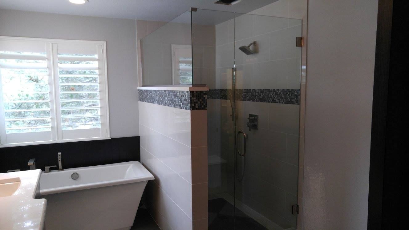 A bathroom with a tub and a walk in shower.