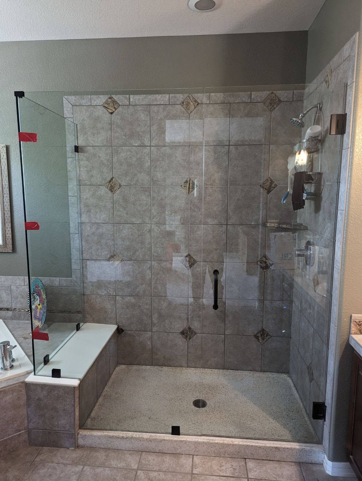 A bathroom with a walk in shower with a glass door.