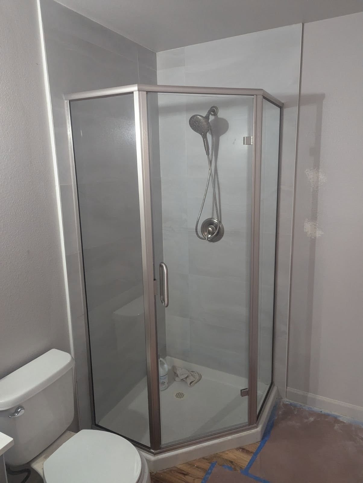 A bathroom with a toilet and a shower stall.