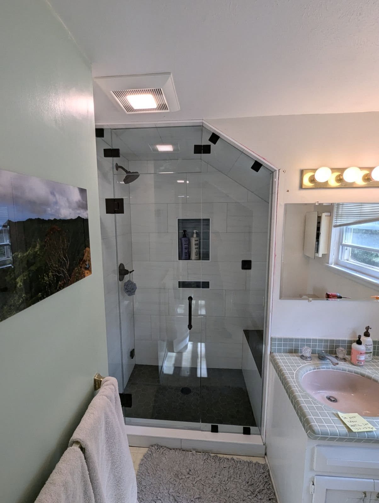A bathroom with a walk in shower and a sink.