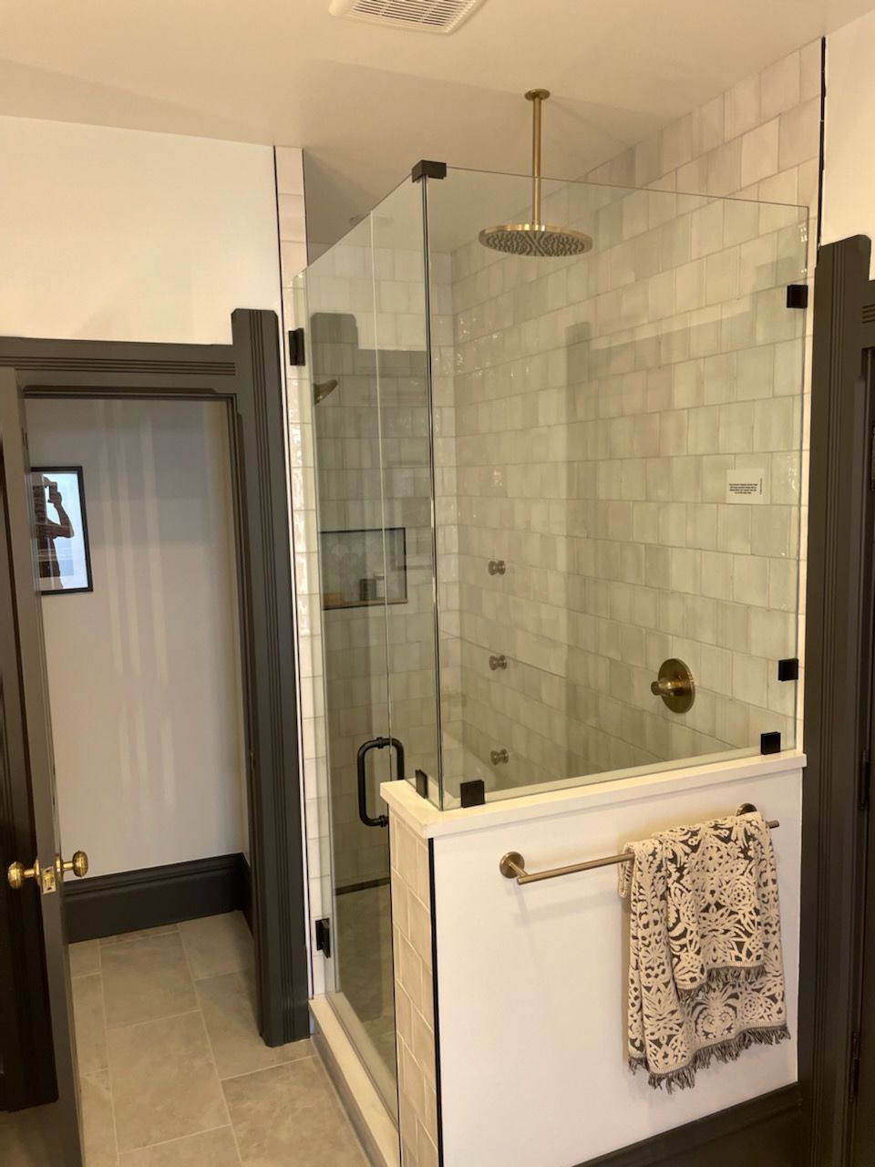 A bathroom with a walk in shower and a towel rack