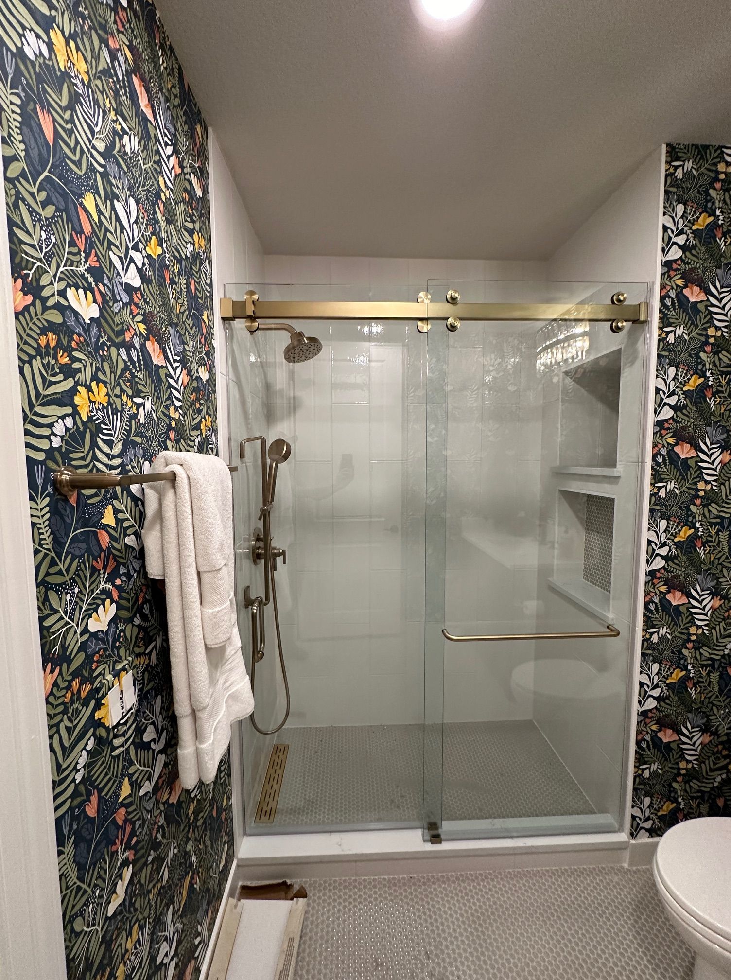 A bathroom with a sliding glass shower door and a toilet.