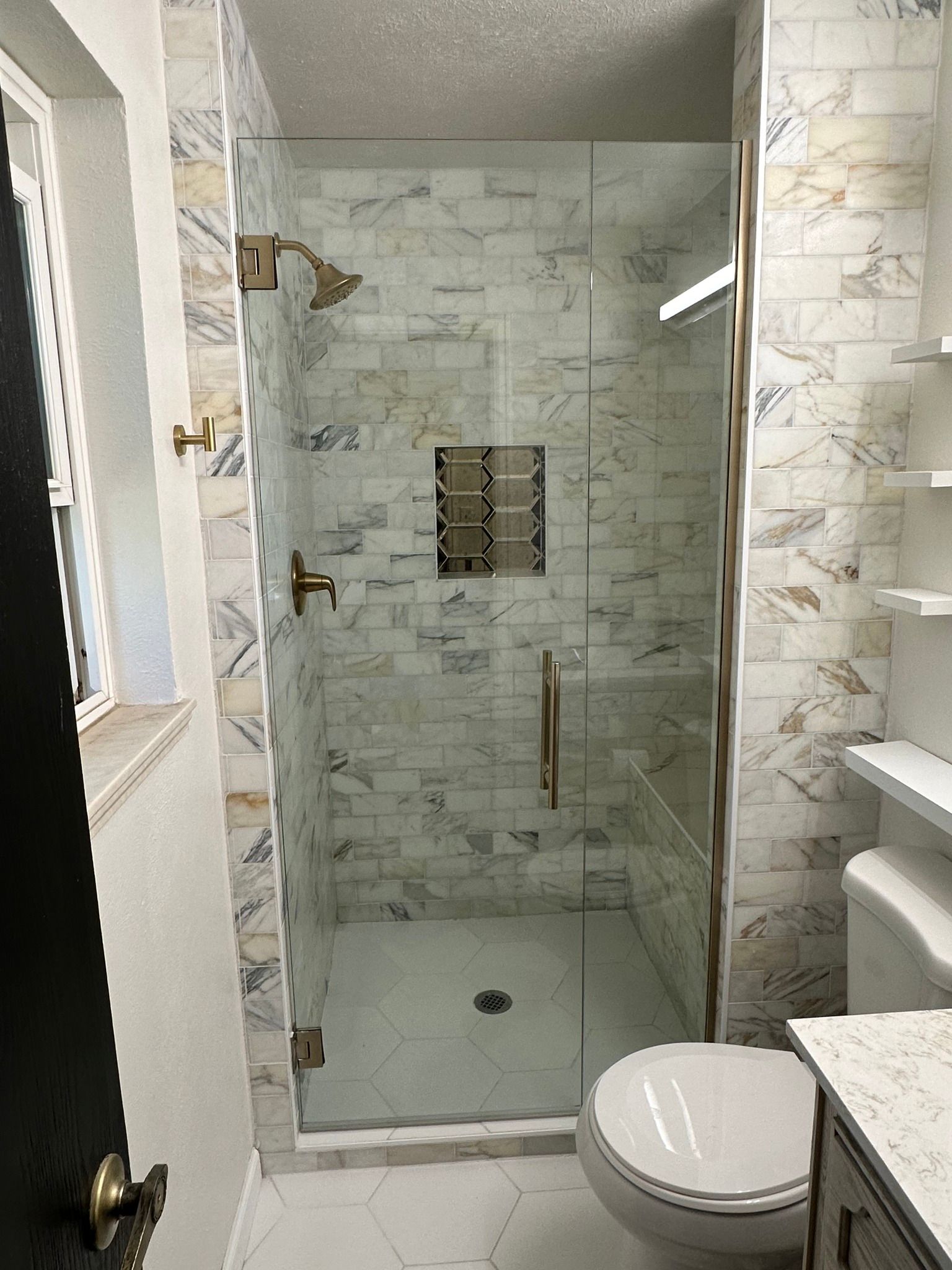 A bathroom with a toilet and a shower with a glass door.