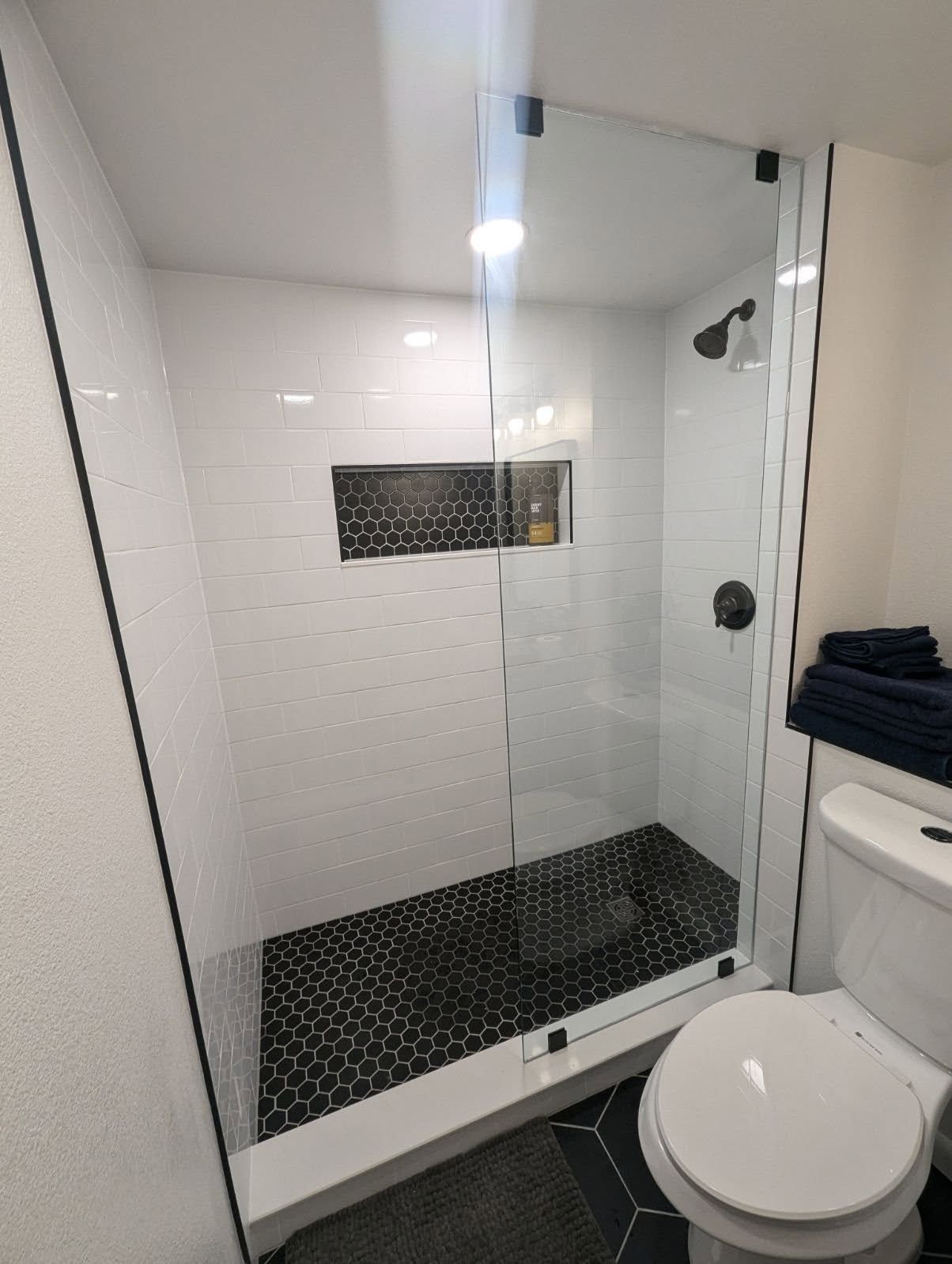 A bathroom with a walk in shower and a toilet.