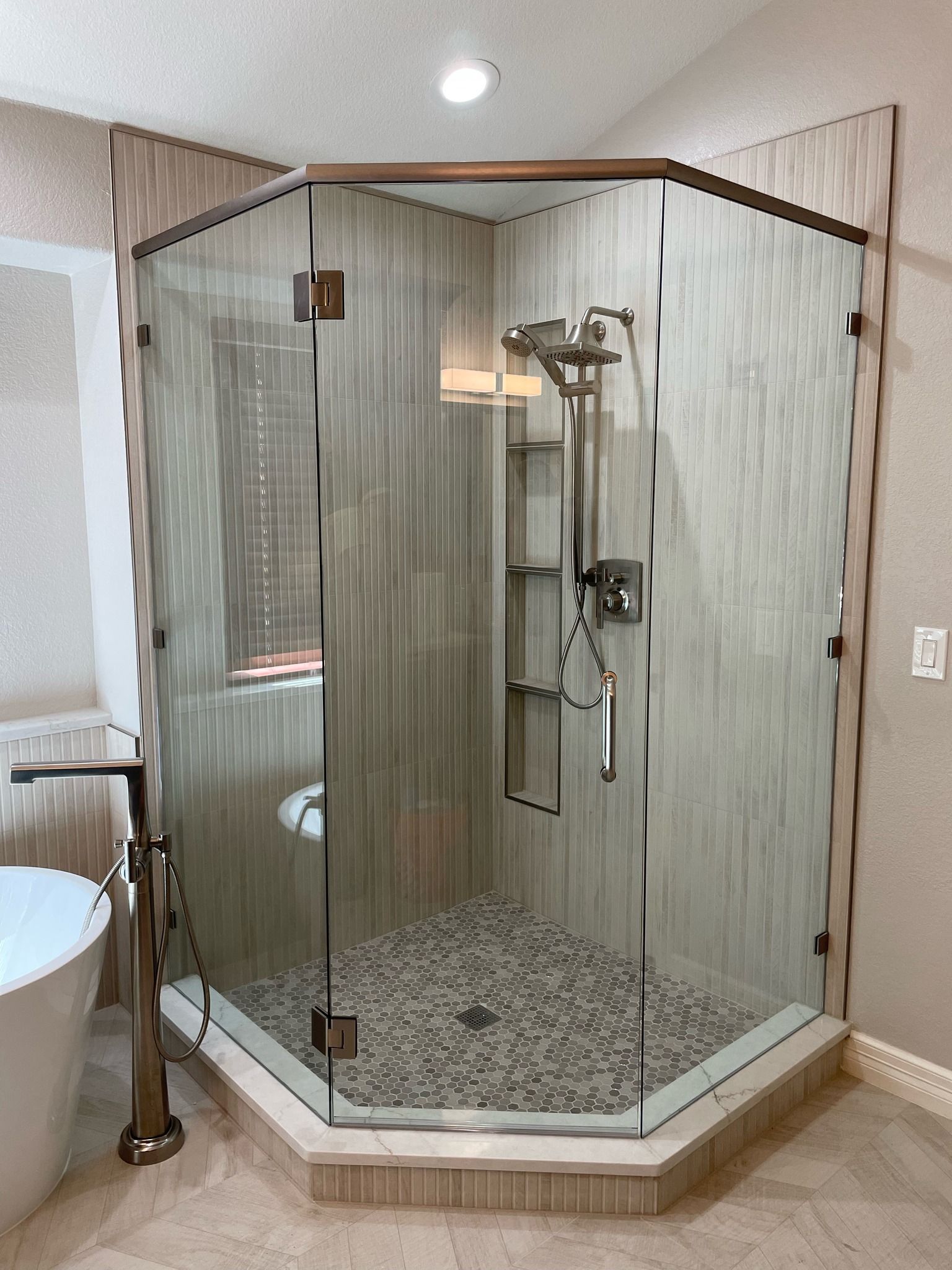 A bathroom with a walk in shower and a bathtub.