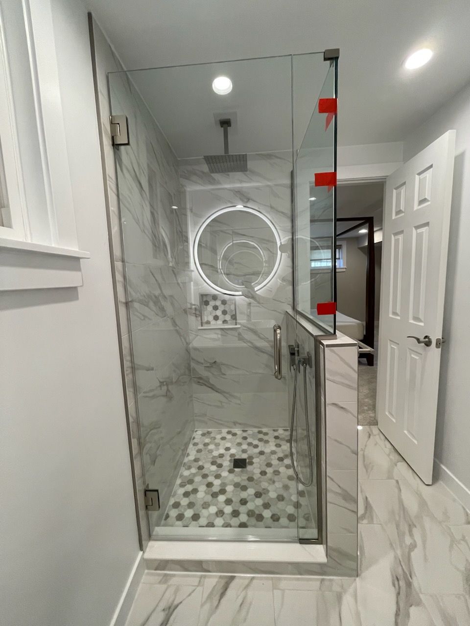A bathroom with a walk in shower and a mirror.