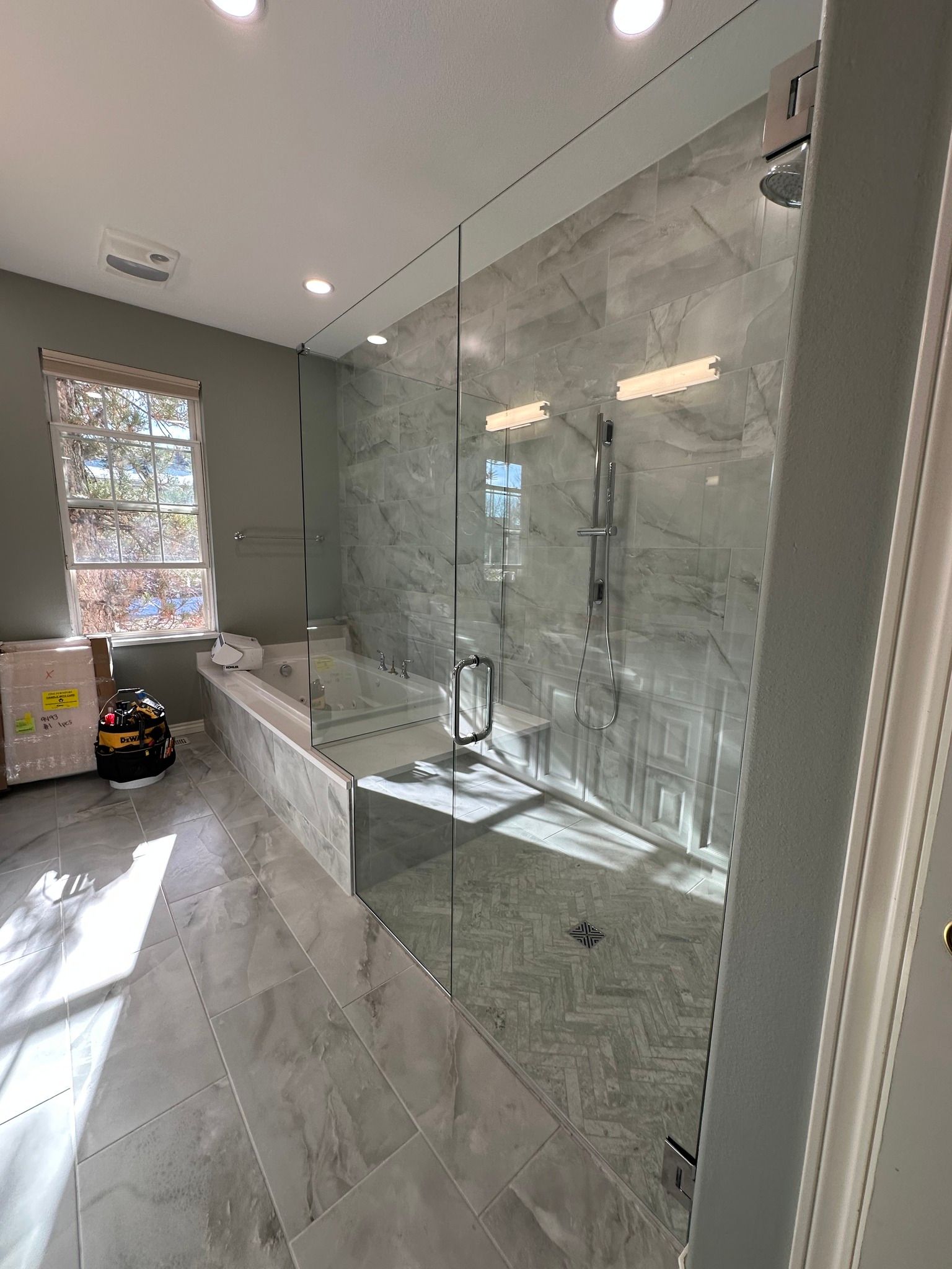 A bathroom with a bathtub and a shower with a glass door.