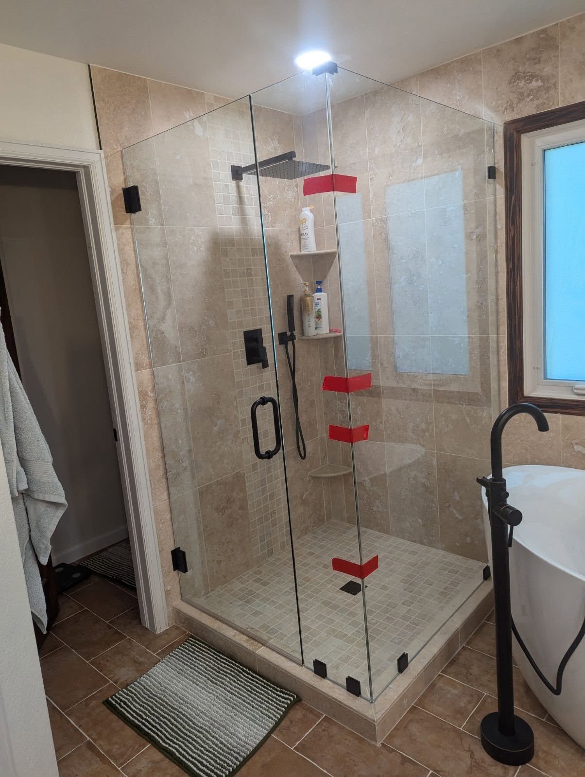 A bathroom with a walk in shower and a bathtub.