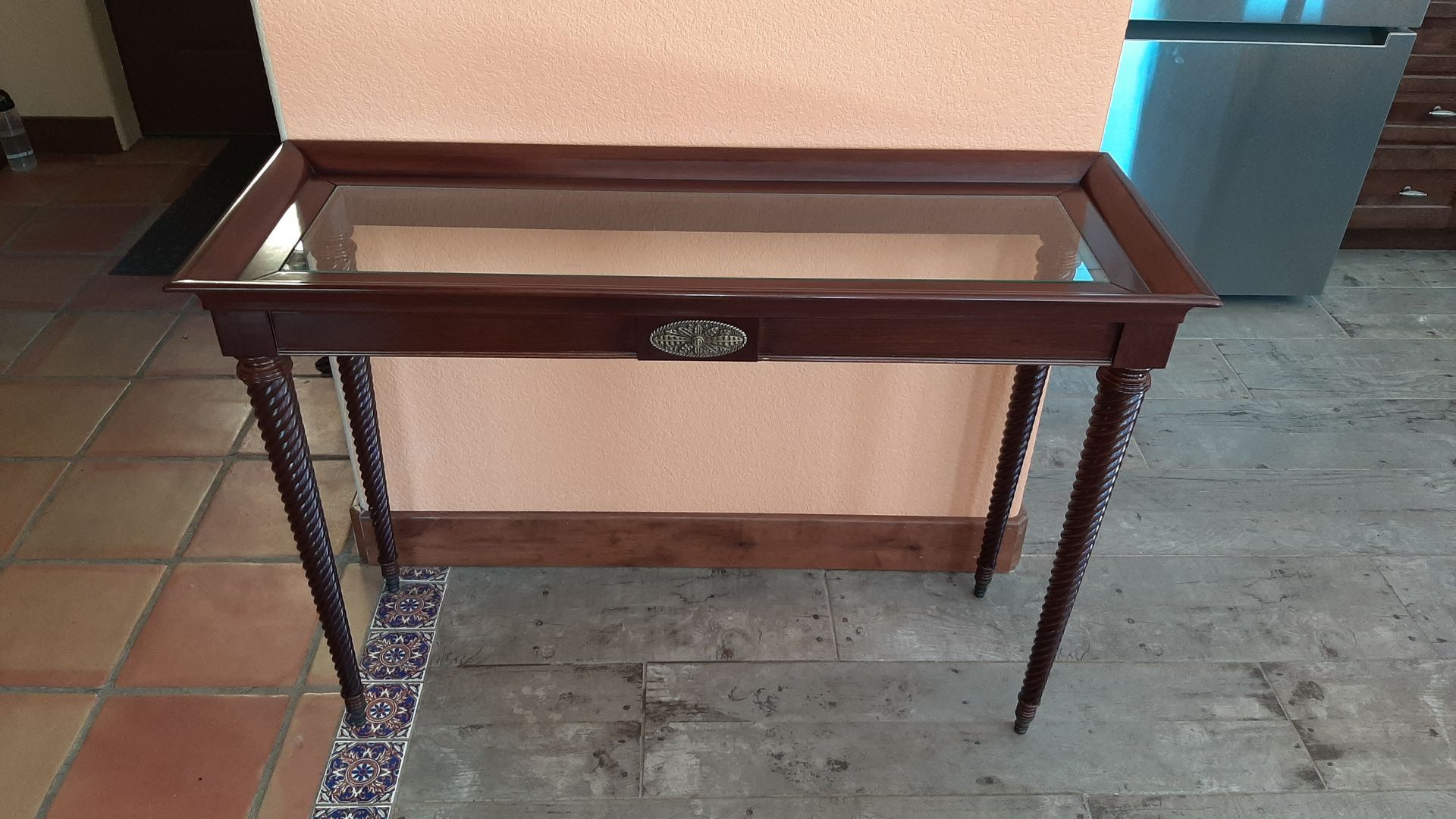 A small wooden table with a glass top